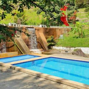 a swimming pool with a waterfall in a yard at Flat completo do Rodeadouro in Bonito +24 photos