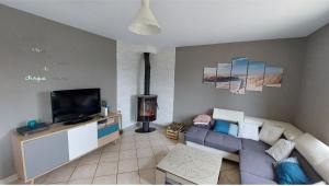 a living room with a blue couch and a tv at Maison avec jardin pour 7 pers à Vibraye - Perche 2h de Paris - 45 min circuit 24h du Mans in Vibraye