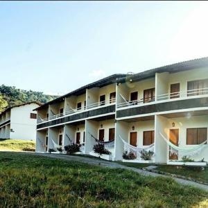 a large white building with a lawn in front of it at Flat completo do Rodeadouro in Bonito