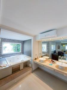 a large bathroom with two sinks and a tub at Gala Apart Boutique & Spa -sólo para adultos- in Mar de las Pampas