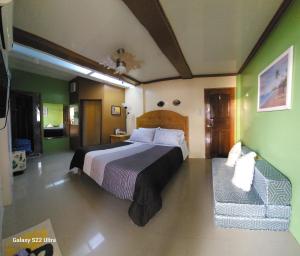 Libagon的住宿－CHUE&LARRY'S BEACHSIDE HOMESTAY，一间卧室配有一张大床和一张沙发