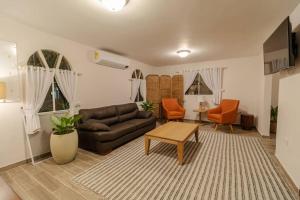 a living room with a couch and a table at Hermosa Casa con piscina Prado Santa marta in Santa Marta