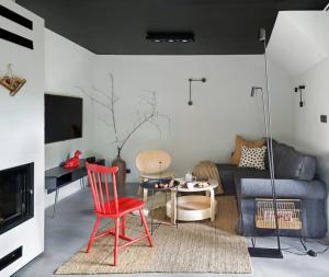 a living room with a couch and a red chair at Apartament Czerwona Łasica in Jaworki