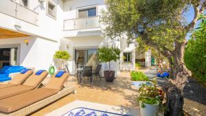 een patio met stoelen en een boom voor een gebouw bij Ocean View Villa in Boliqueime