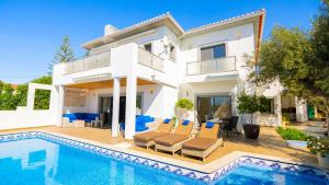 een villa met een zwembad en een huis bij Ocean View Villa in Boliqueime