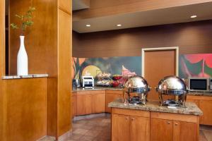 a kitchen with wooden cabinets and stainless steel appliances at Fairfield Inn Sacramento Cal Expo in Sacramento