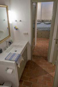 a bathroom with a sink and a mirror and a bed at Patmos Traditional House Chora near the Monastery in Patmos