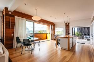 een keuken en een woonkamer met een tafel en stoelen bij Oneroa Beach Apartment in Blackpool