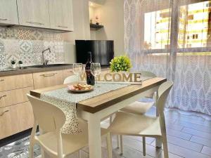 a kitchen with a table and chairs with wine glasses at Casa vacanze “Dolce sosta” in Quartu SantʼElena