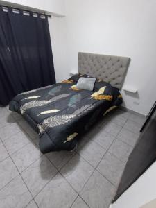 a bedroom with a bed with a black and yellow comforter at Depto Caba Floresta in Buenos Aires