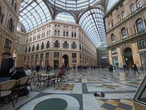 un gran edificio con techo abovedado de cristal con personas sentadas en mesas en Fifth Floor en Nápoles