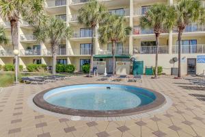 a swimming pool in front of a building with palm trees at The Summit 1502 in Panama City Beach