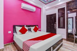 um quarto com uma parede rosa e uma cama em Super OYO The Prima Residency em Ghaziabad