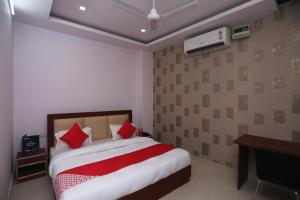 a bedroom with a large bed with red pillows at OYO Hotel Blueberry in Faridabad