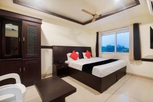 a hotel room with a bed and a window at Capital O Hotel Alfa in Vijayawāda