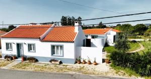 una casa blanca con techo naranja en A Quinta da Estrelinha en Quinta de Cavaleiros