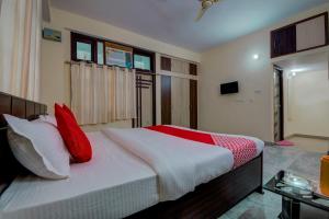 a bedroom with a large bed with red pillows at Super Hotel O Rajbanshi Nagar in Patna