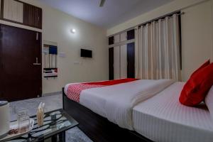 1 dormitorio con cama, mesa y TV en Super OYO Flagship Rajbanshi Nagar en Patna