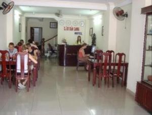 a group of people sitting at tables in a restaurant at Lam Bao Long Hotel in Hue