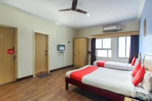 Ameerpet的住宿－OYO Luxury Villas Near Begumpet Airport，一间酒店客房,设有两张床和电视