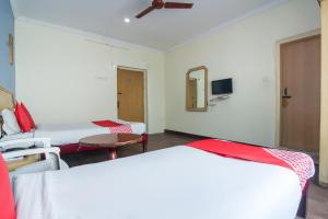 OYO Luxury Villas Near Begumpet Airport في Ameerpet: غرفة بسريرين وطاولة ومرآة