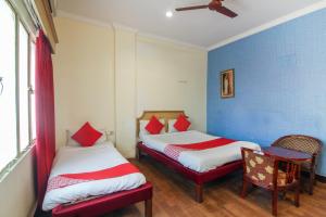 OYO Luxury Villas Near Begumpet Airport في Ameerpet: سريرين في غرفة بجدران زرقاء