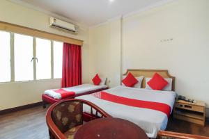 OYO Luxury Villas Near Begumpet Airport في Ameerpet: غرفة فندقية بسريرين وكرسي
