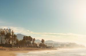 a view of a beach with palm trees and buildings at Ona Marinas de Nerja Spa Resort in Nerja