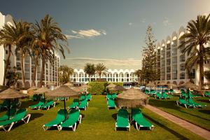 a group of lawn chairs and umbrellas in a resort at Ona Marinas de Nerja Spa Resort in Nerja