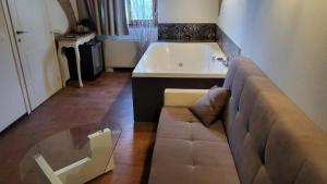 a living room with a couch and a bath tub at Villa Ca' Viola Rimini in Rimini