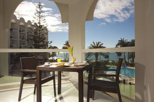 a dining room with a table and chairs on a balcony at Marinas de Nerja Beach & Spa in Nerja