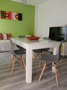 einen weißen Tisch mit 2 Stühlen und einen TV in der Unterkunft Apart Pm Albatros in Necochea