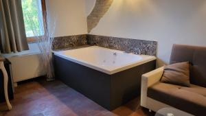 a bath tub in a room with a couch at Villa Ca' Viola Rimini in Rimini