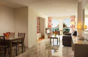 a living room with a couch and a table with chairs at Marinas de Nerja Beach & Spa in Nerja