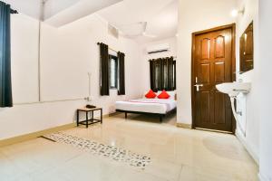a room with a bed and a sink and a door at OYO Flagship Ag Colony in Patna