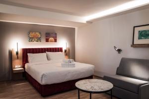 um quarto de hotel com uma cama e uma cadeira em Urban Frame Acropolis em Atenas