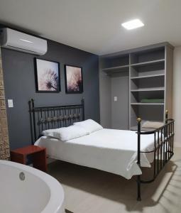 1 dormitorio con cama y bañera en Loft Espaço Vila da Serra en Nova Lima