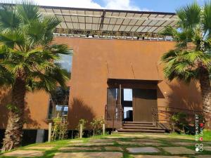 a building with palm trees in front of it at Loft Espaço Vila da Serra in Nova Lima