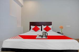 a bedroom with a bed with red pillows at Sai Krishna Residency in Vijayawāda