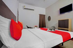 um quarto de hotel com uma cama grande com almofadas vermelhas em Sai Krishna Residency em Vijayawada
