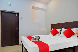 a bedroom with a bed with red and white pillows at Sai Krishna Residency in Vijayawāda