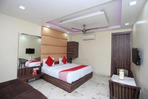 een hotelkamer met een bed en een spiegel bij Super OYO Hotel Samrat in Gurgaon