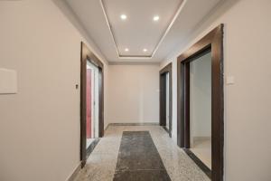 um corredor com portas e janelas num edifício em Capital O La Grace Premium em Khandagiri