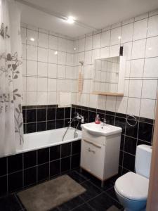 uma casa de banho com um lavatório, um WC e uma banheira em "Kurhause" namai em Klaipėda