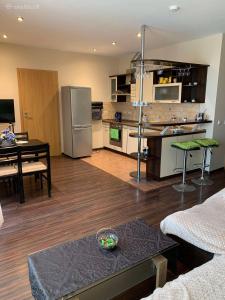 uma cozinha e sala de estar com uma mesa e um frigorífico em "Kurhause" namai em Klaipėda