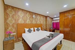 um quarto com uma cama grande e uma parede de madeira em Collection O Pride Hospitality US Consulate em Chennai