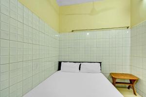 a small room with a bed and a table at OYO 86379 Dream Palace Guest House Near Marina Beach in Chennai