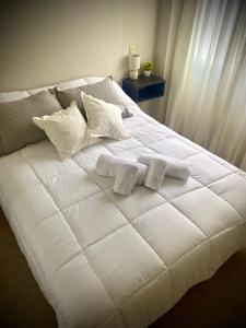 uma grande cama branca com duas almofadas em Gertrudis - Central Point Apartments em Salta