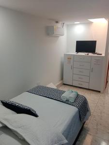 a bedroom with a bed and a desk with a computer at Mar de Indias House in Cartagena de Indias +48 photos