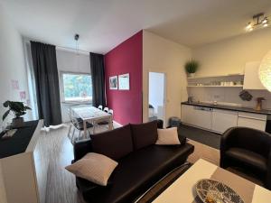 a living room with a black couch and a kitchen at Apartment & Boardinghouse Berlin Friedrichshain-Kreuzberg in Berlin